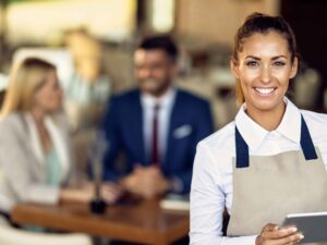 young-happy-waitress-using-touchpad-while-working-cafe (1).jpg